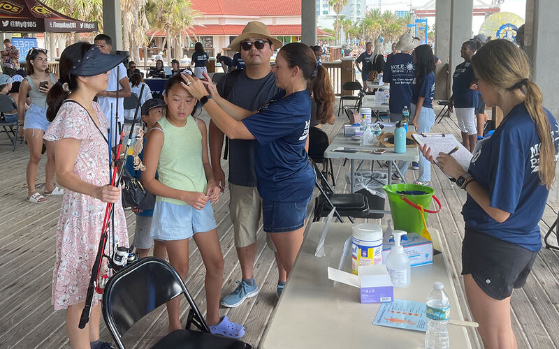 A family gets screened for skin cancer at Pier 60 in 2023.