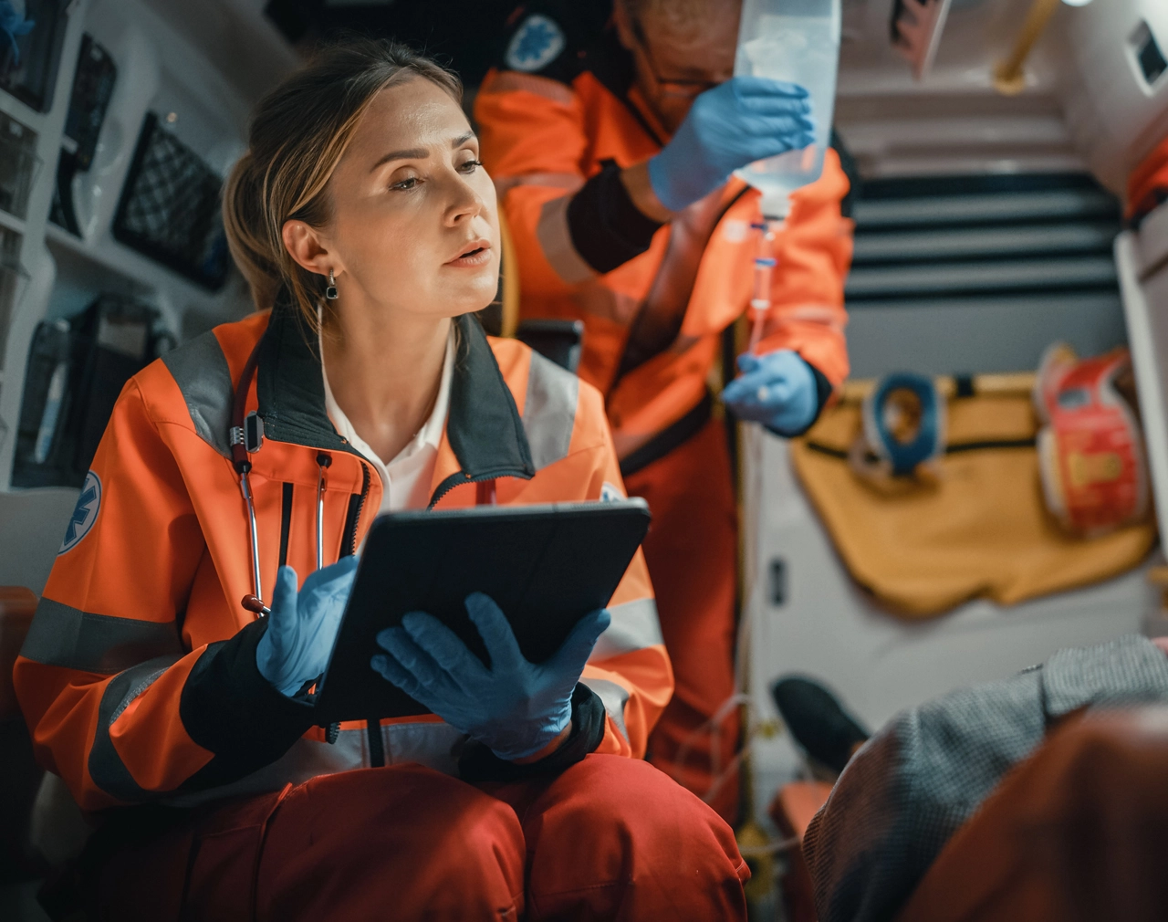 Stock image of a Wireless Networks Emergency Services worker on an ipad in an ambulance