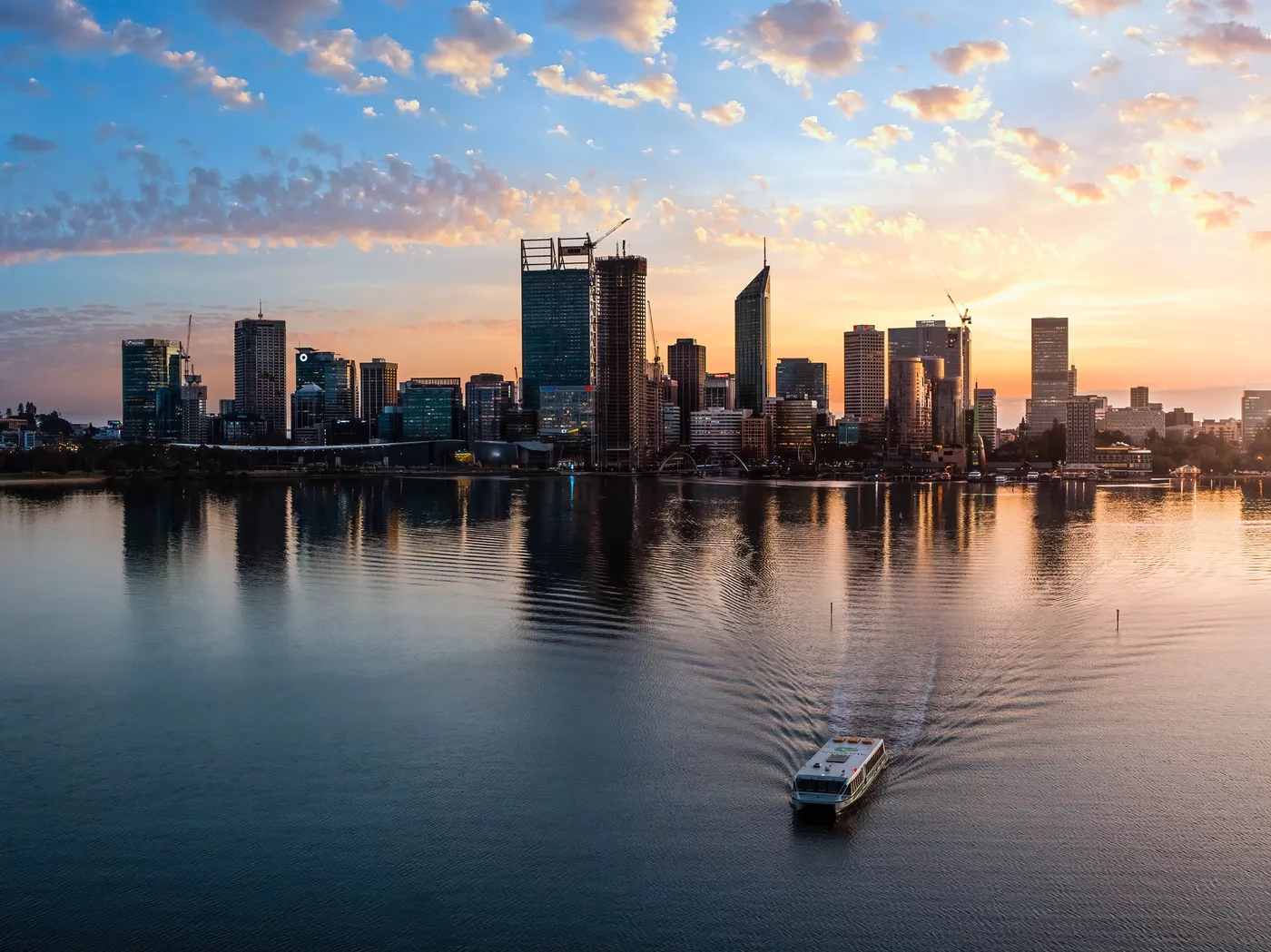 Aerial shot of a Transperth ferry on the Swan River with the Perth city skyline in the background
