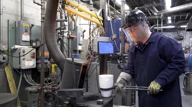 Workers at a machine processing metal