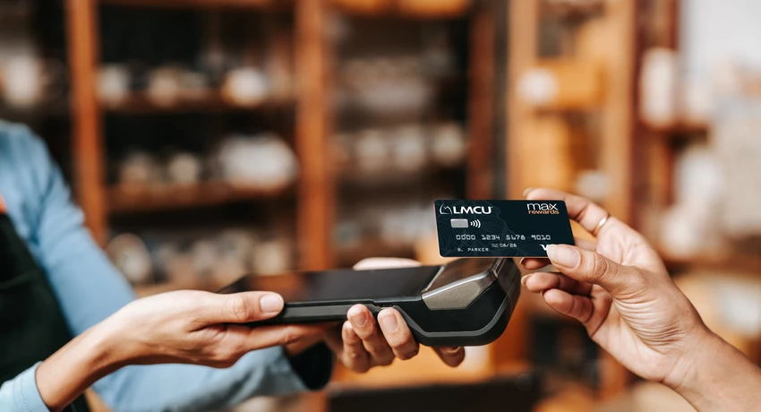 Customer taps a Max Rewards credit card on payment terminal at checkout. 
