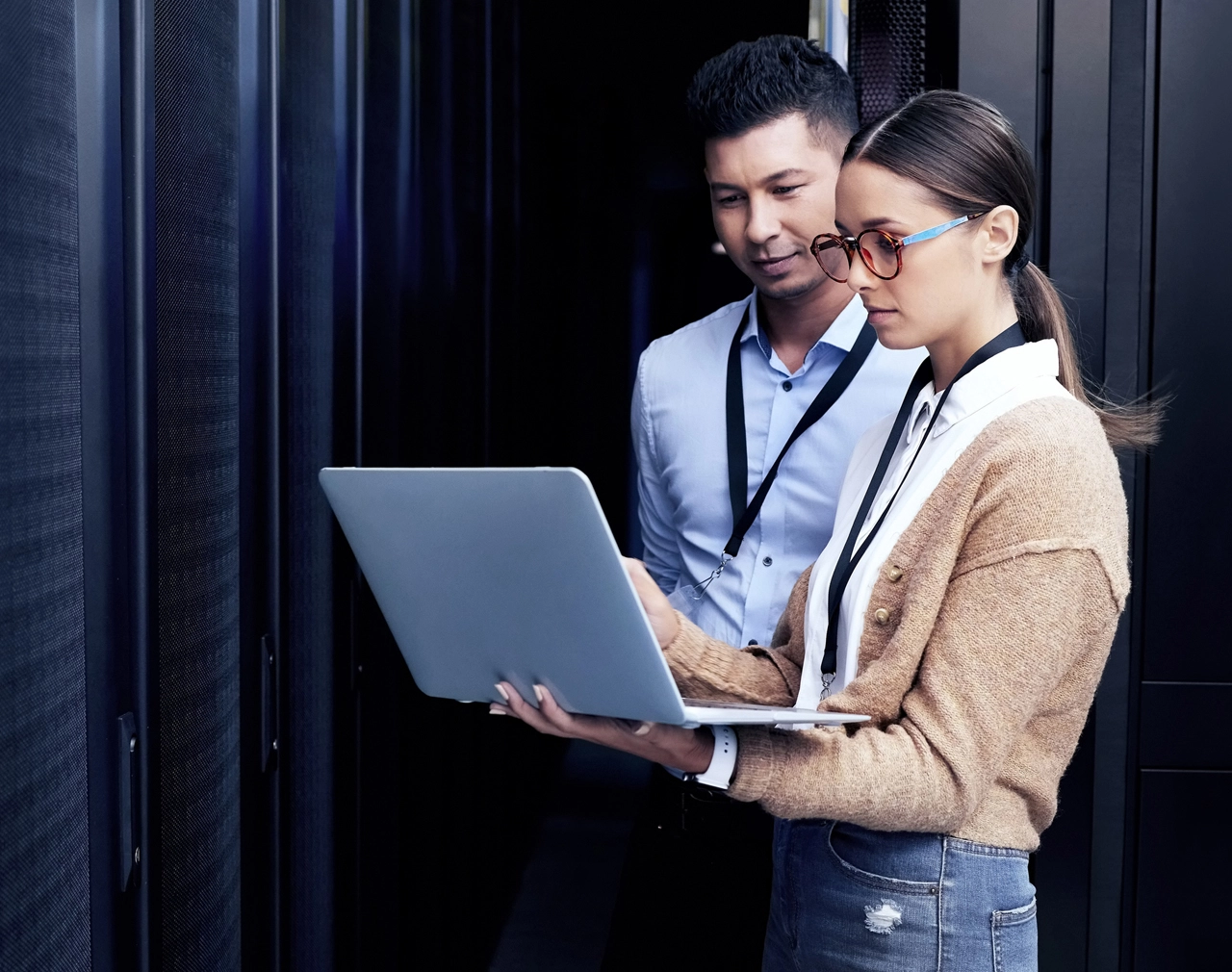 Stock image of two office workers on laptop in data centre