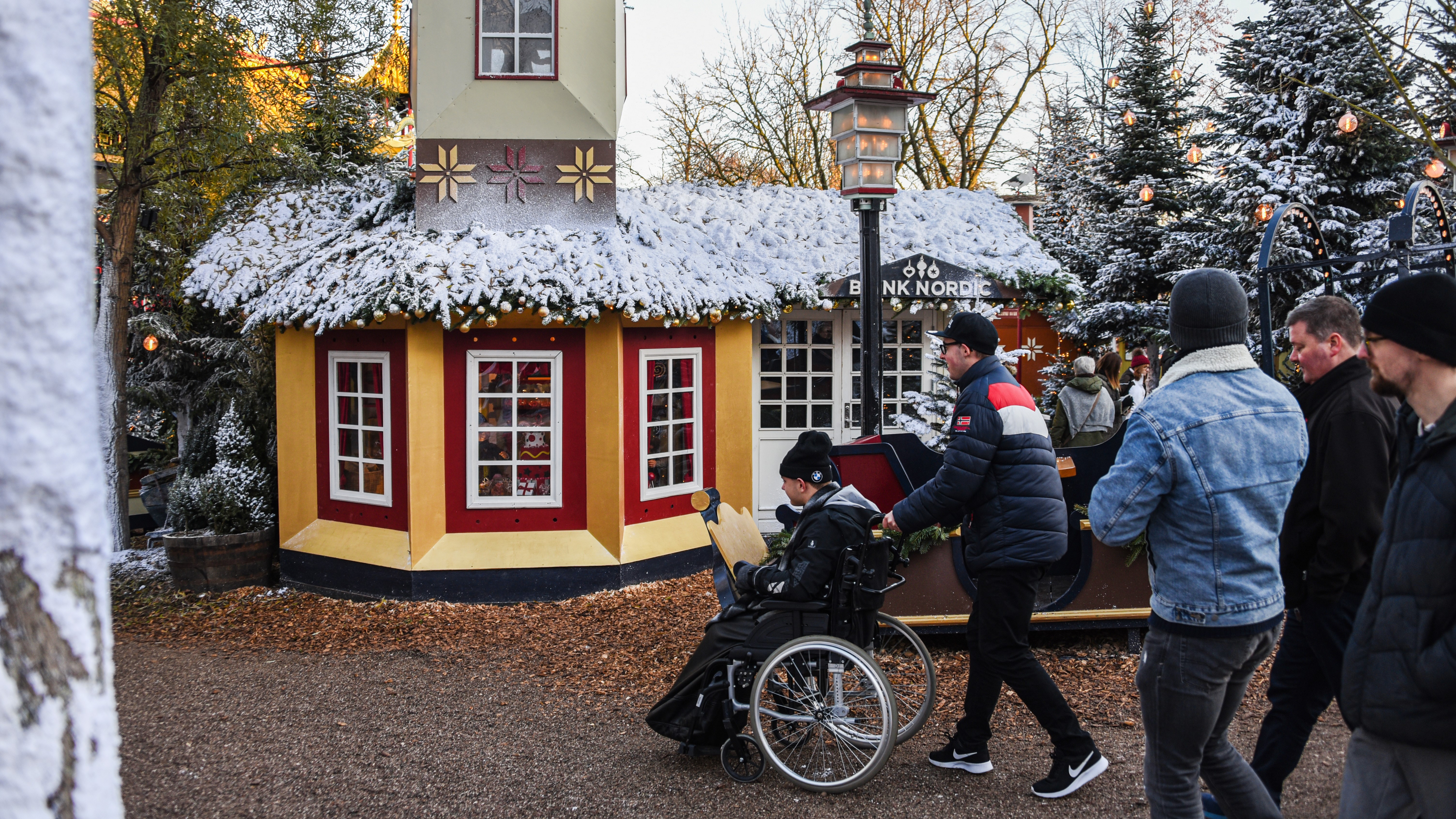 Someone pushing a person in a wheelchair at a festive market