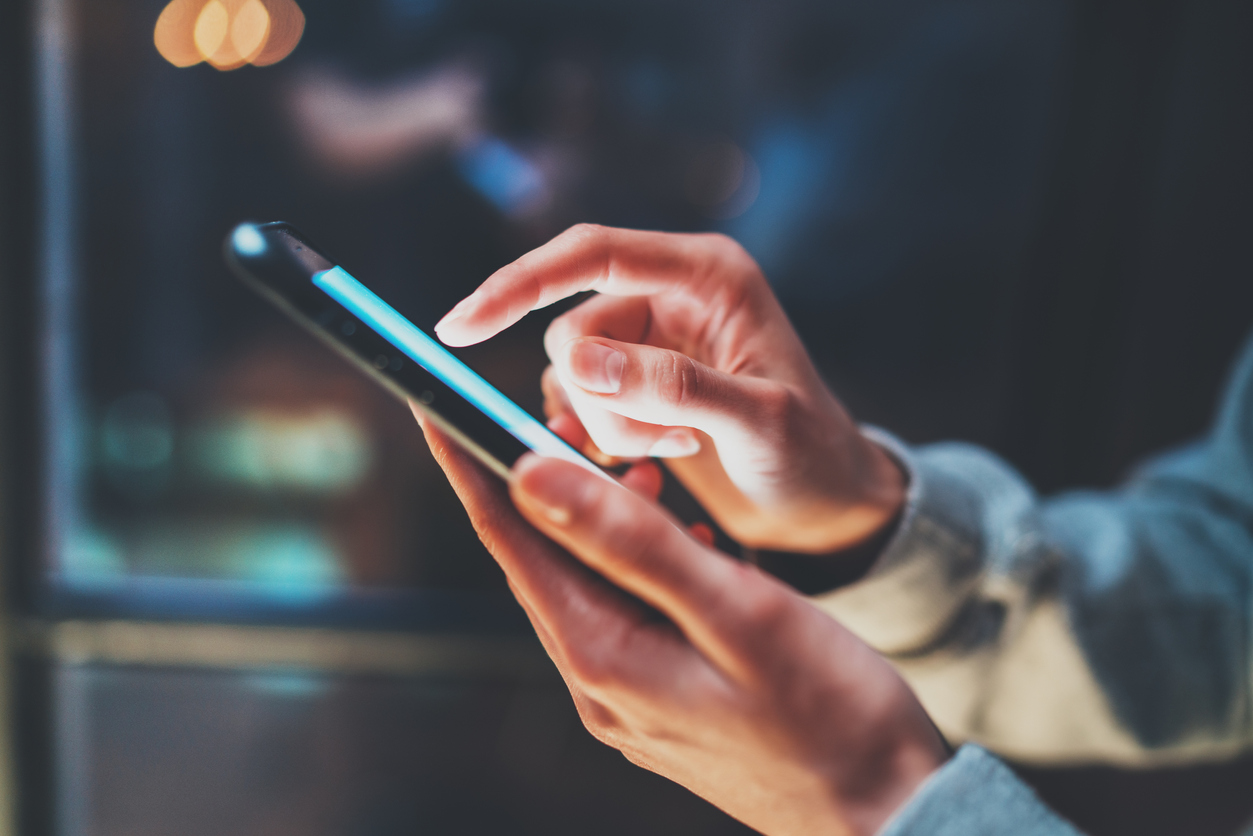 Cell phone in hand of person using touch screen