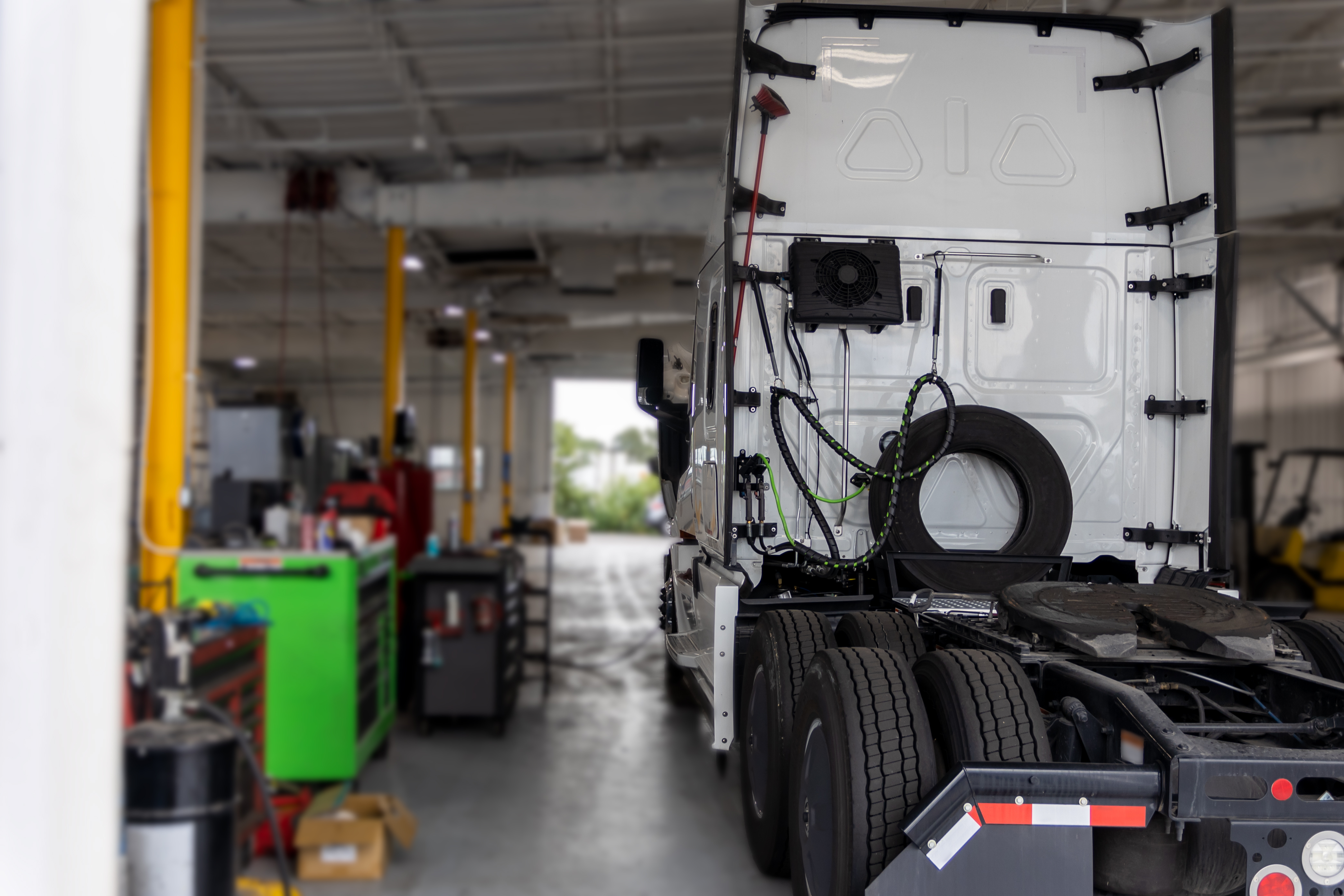 A garage with a semi truck parked inside while receiving a fleet management tune-up.