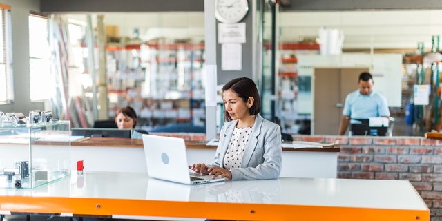 Female business woman in open plan office of a small business