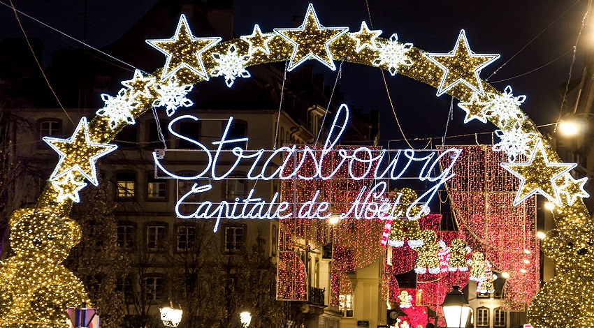 Christmas lights in the shape of stars forming an arch over the lit-up words "Strasbourg: Capitale de Noel"