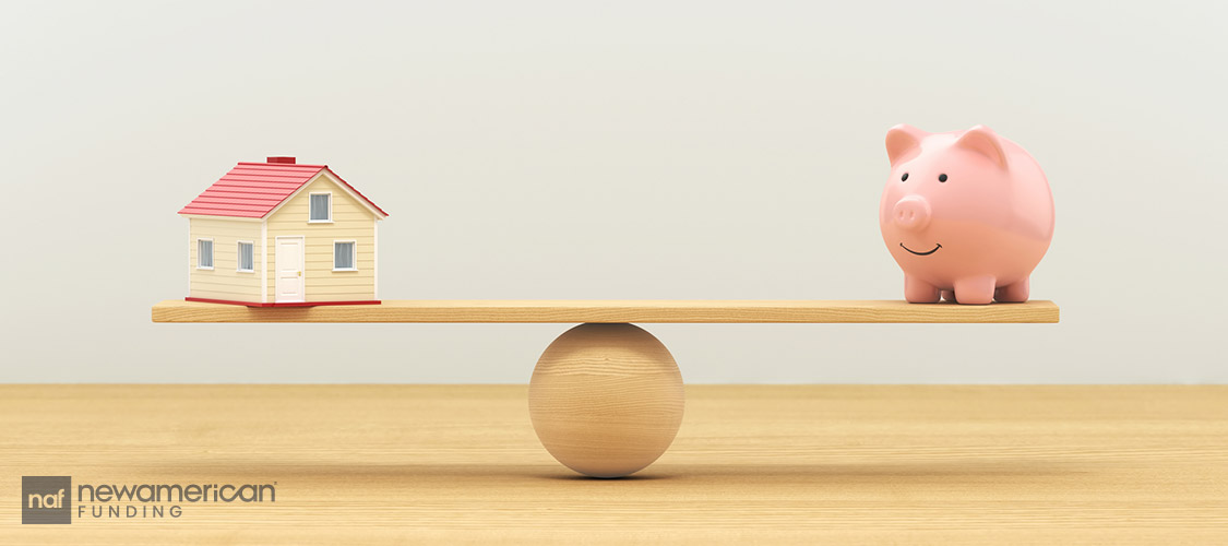 house and piggy bank on balance scale