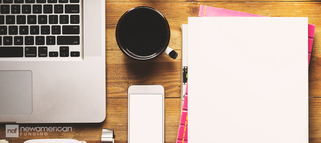 work desk with laptop, coffee, phone and paper