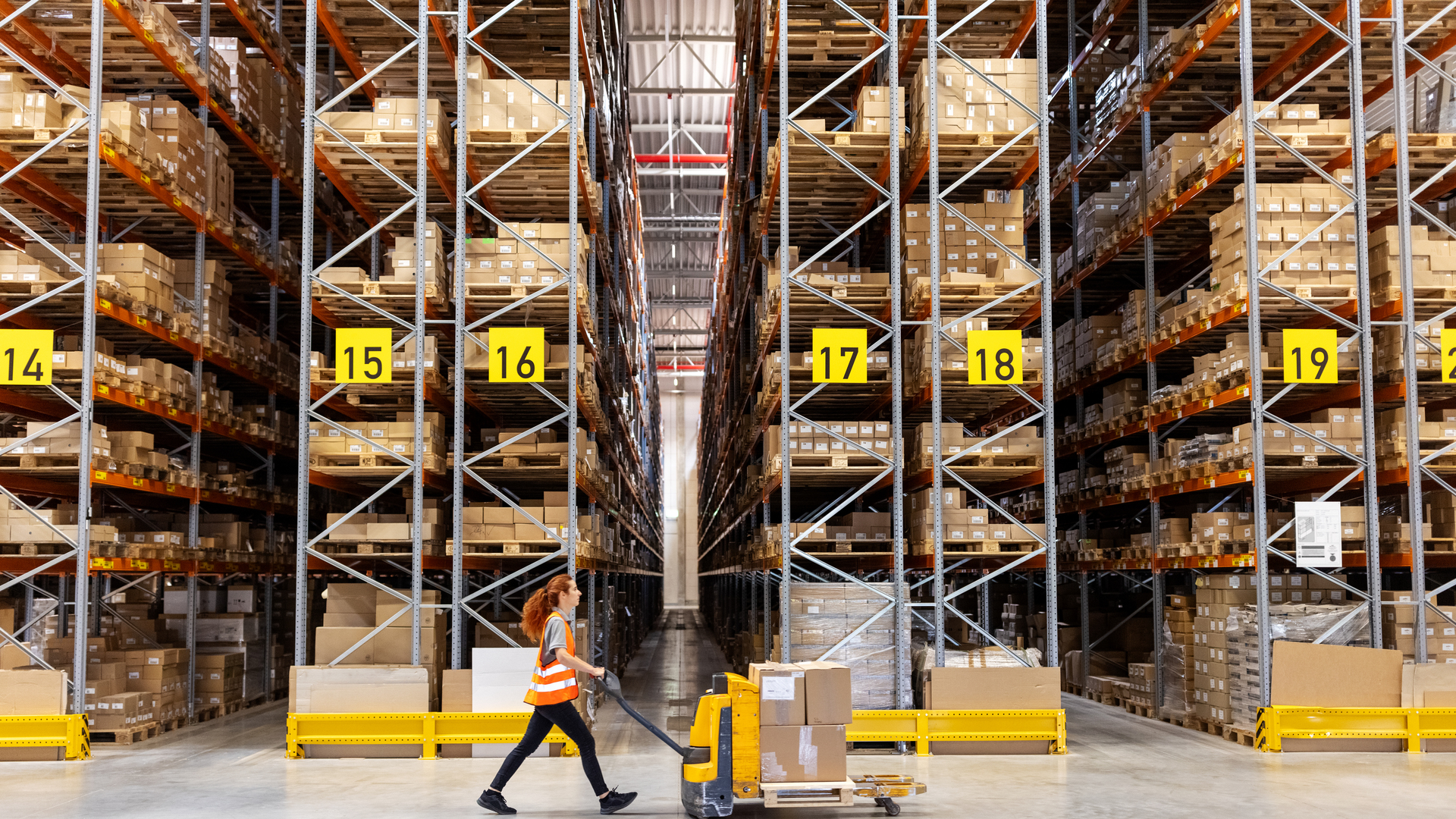 Warehouse worker moving boxes on hand truck