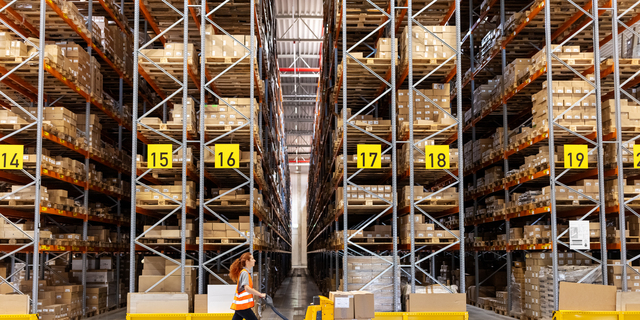 Warehouse worker moving boxes on hand truck