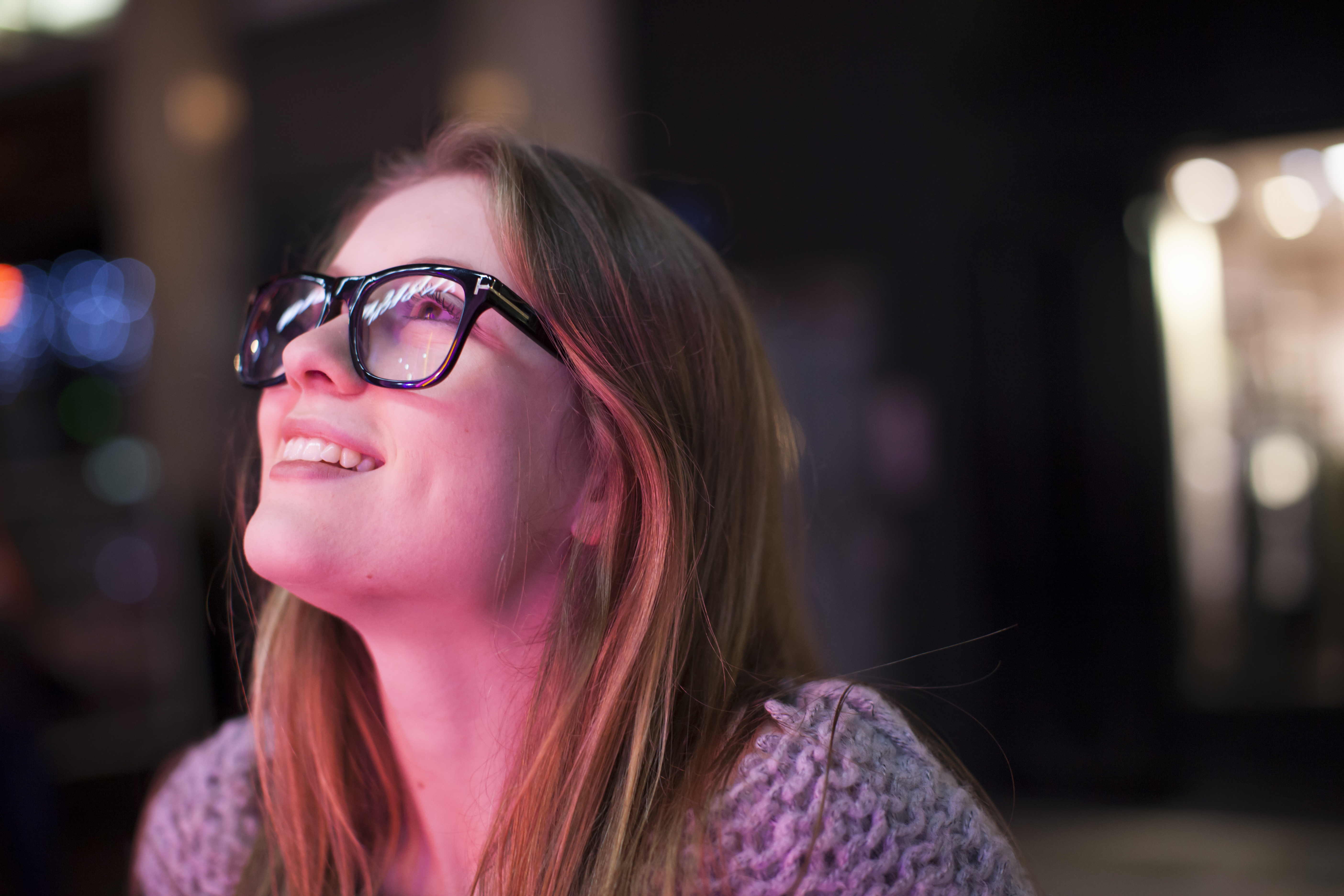 A woman with glasses admires the projection mapping display at the LUMA Projection Arts Festival.