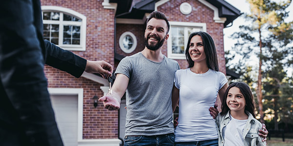 real estate agent handing over home keys to a family