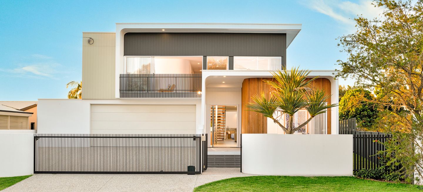 Two level home with driveway and gardens