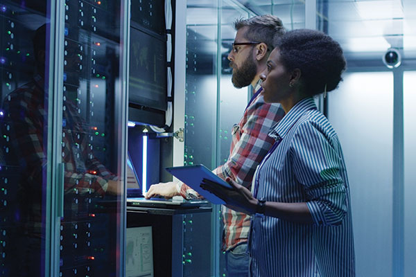 IT specialists managing server racks in a data center