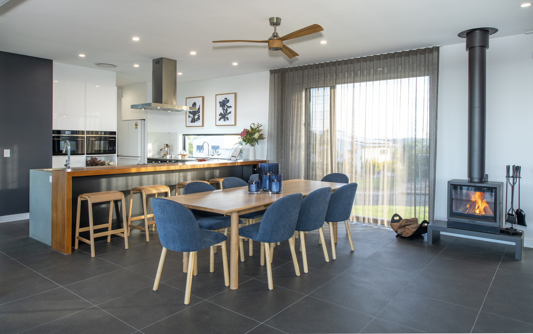 A large Dining set and fireplace in front of a Kitchen  