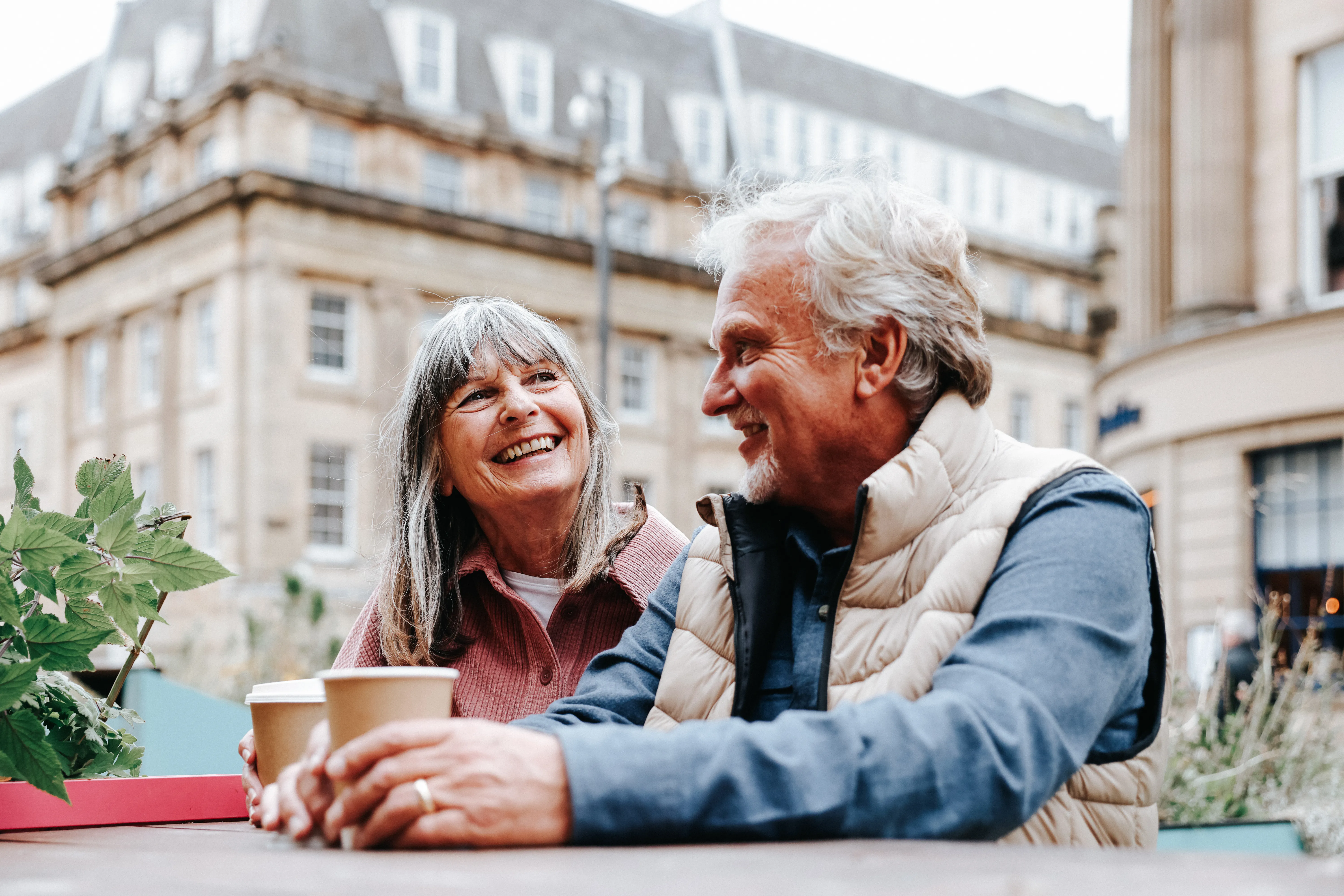  A happy senior couple enjoy a moment together while seated at an outdoor café 