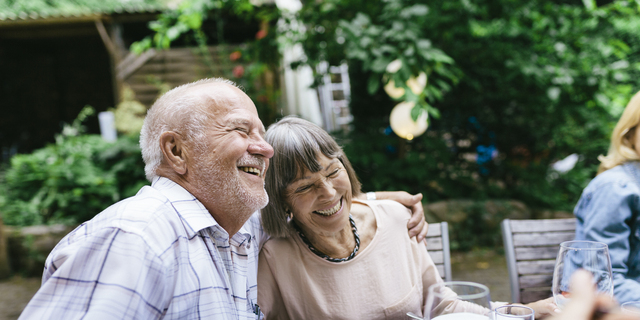 Elderly Couple Enjoying Outdoor Meal With Family