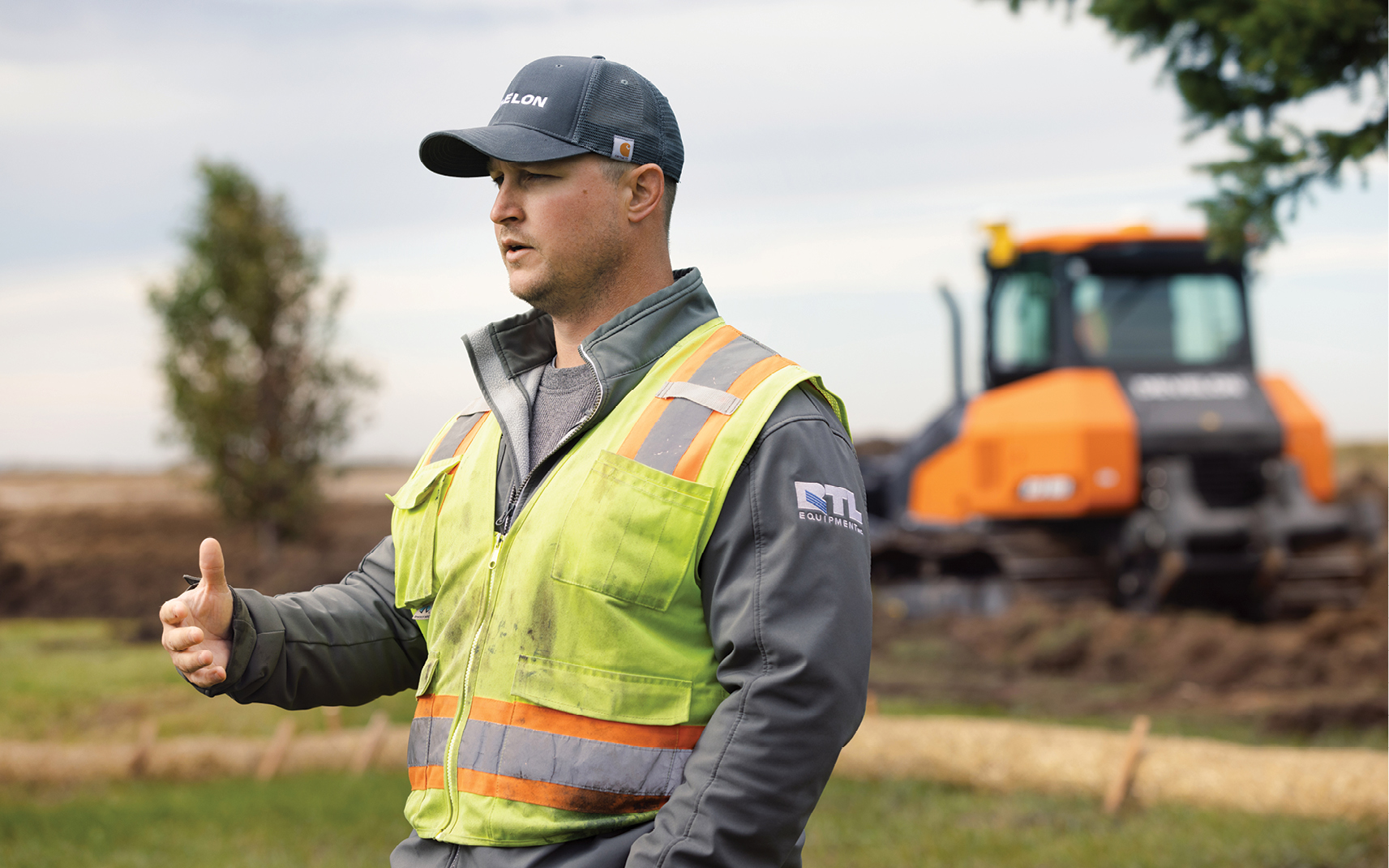 Dalton Rasch of Rasch Construction is interviewed with a DEVELON dozer in the background.