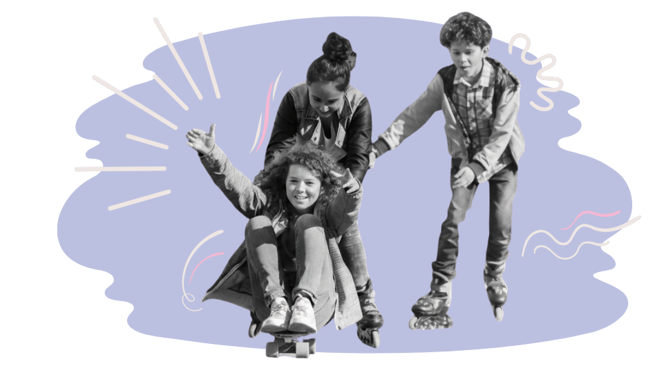 Two teens no roller blades pushing another teen who is sitting on a skateboard.