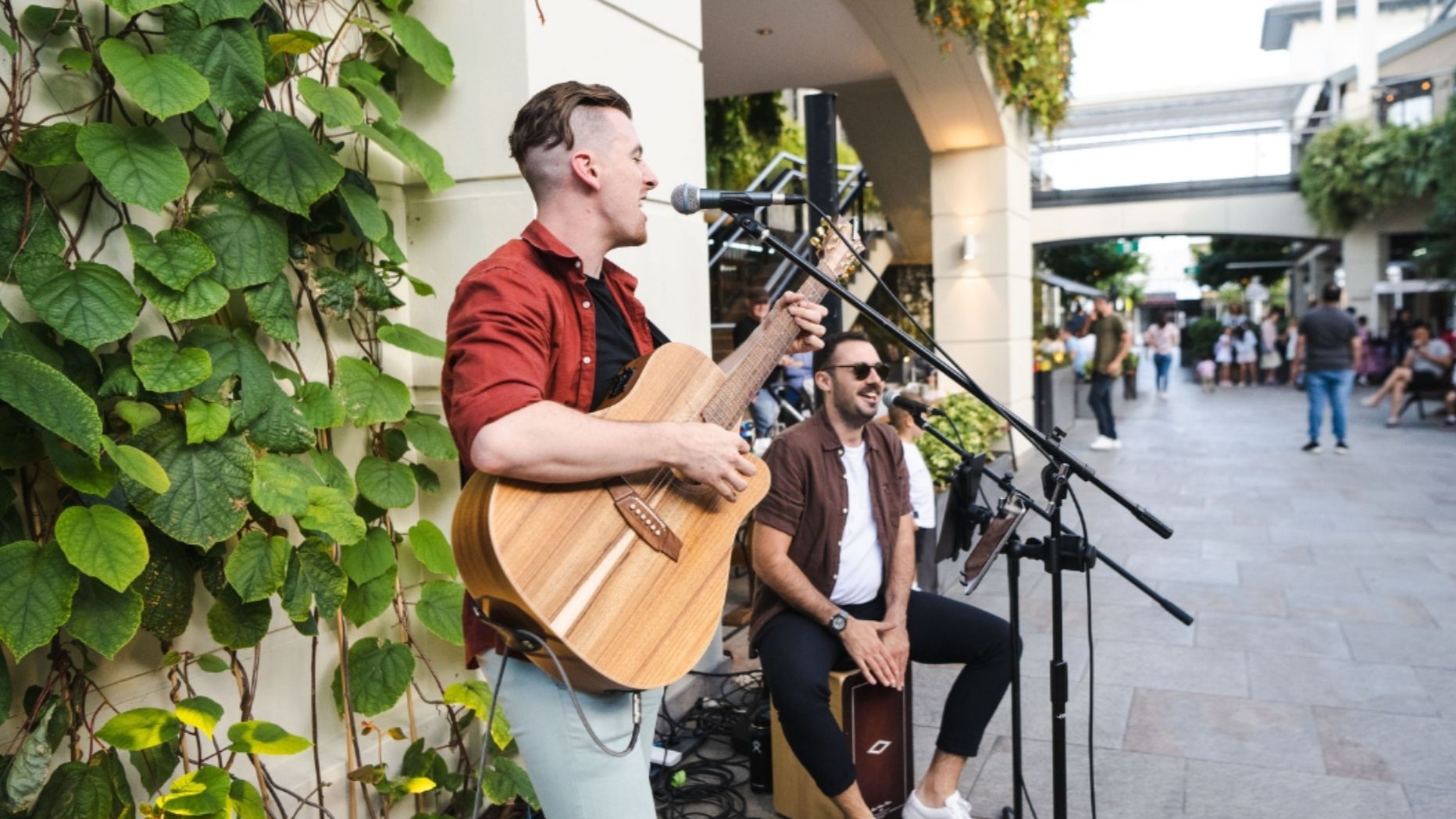 Two musicians playing live acoustic music in The Piazza