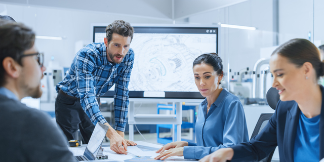 Modern Factory Office Meeting Room: Busy Diverse Team of Engineers, Managers and Investors Talking at Conference Table, Use Interactive TV, Analyze, Find Solutions, Debate and Discuss Engine Concept