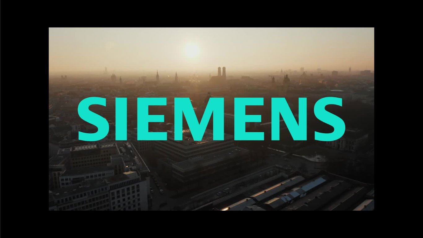 SIEMENS in bold teal letters over a hazy aerial view of a city skyline at sunrise.