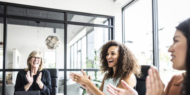 Business colleagues applauding in conference room