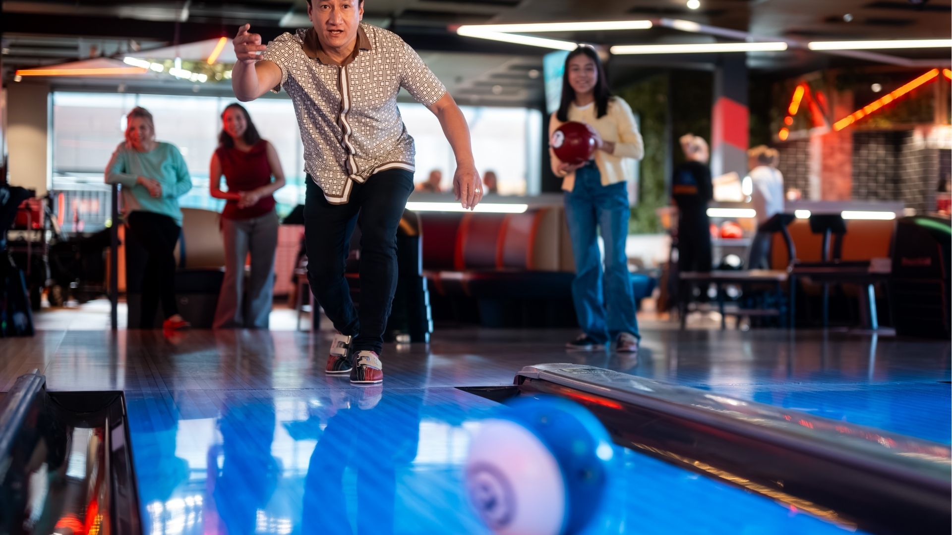 Father bowling a ball and enjoying time with his family.
