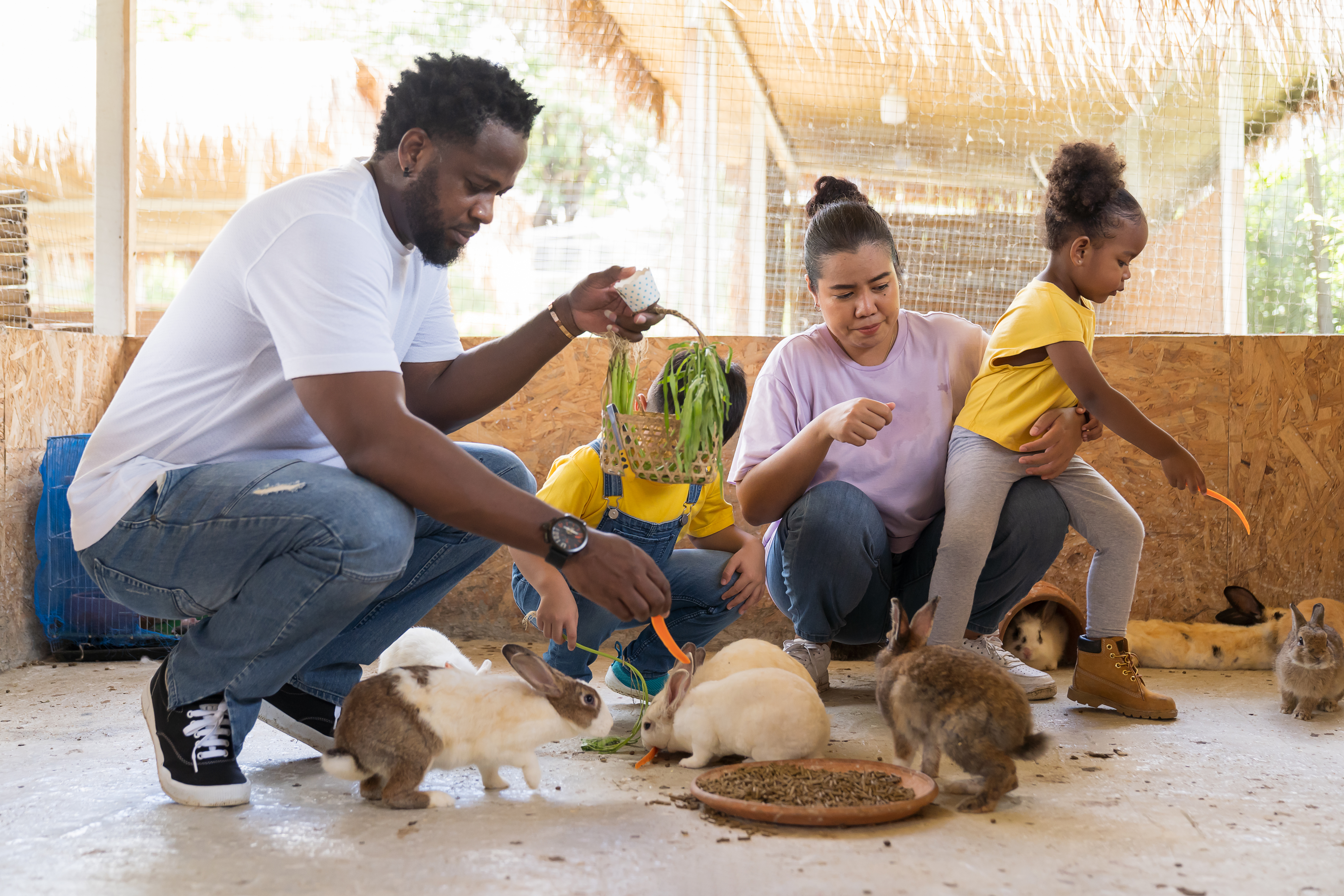 Family at a farm playing with rabbits