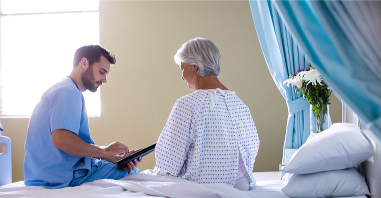 doctor-reviewing-data-with-patient-in-hospital-room.jpg