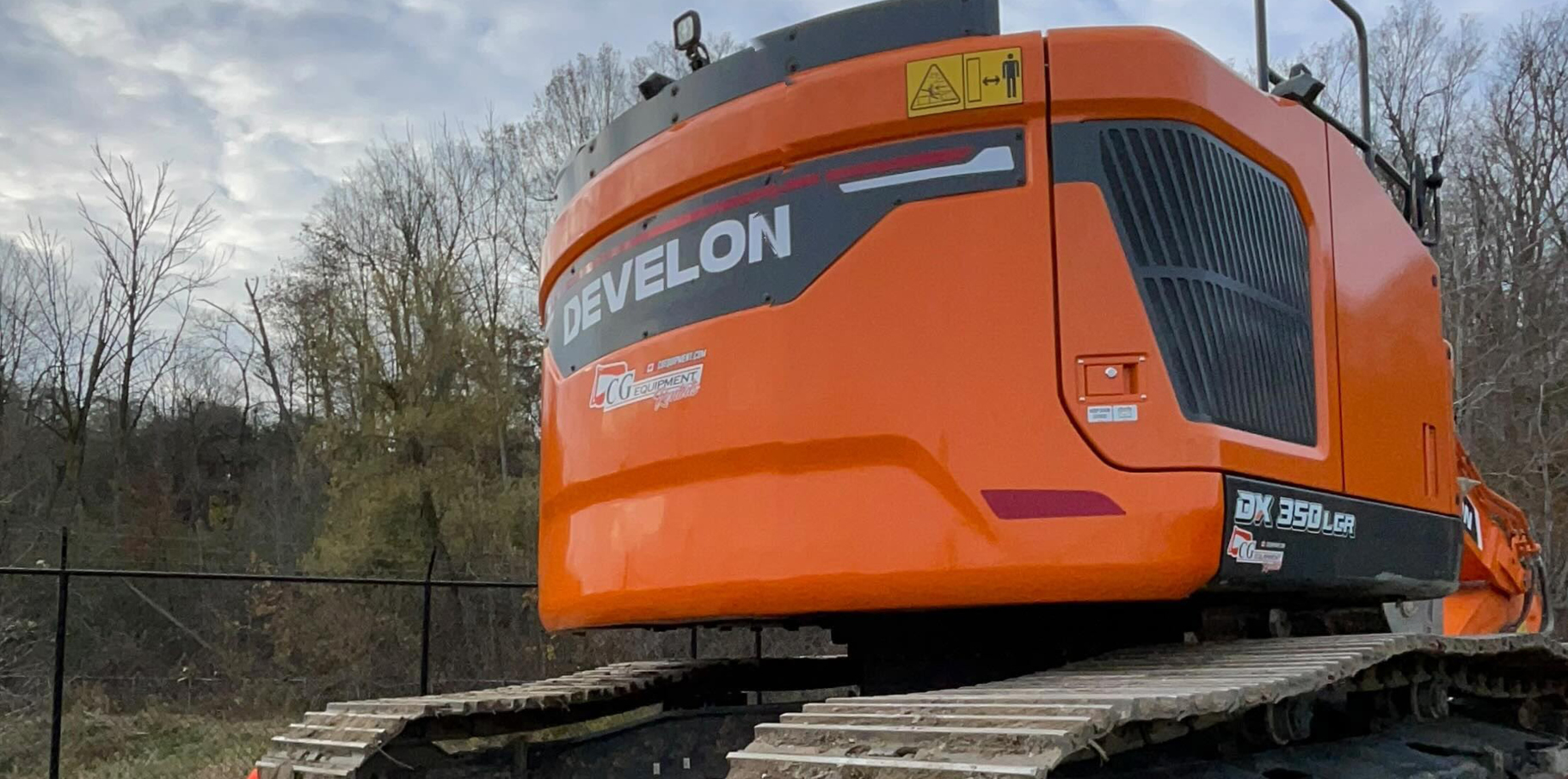 Close-up of the back end of a DEVELON excavator on a job site.