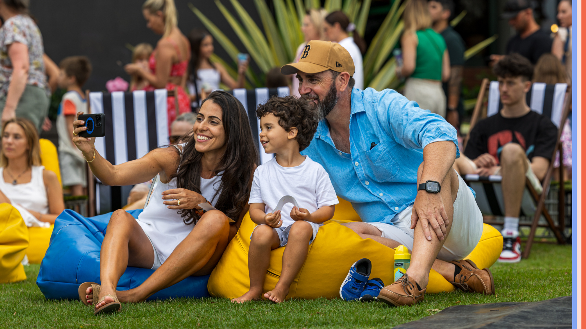 image of family smiling and sitting on bean bags, outside at robina town centre, taking a family photo