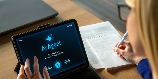 Professional businesswoman working at a desk while interacting with an AI assistant on a tablet screen. The scene shows a modern office environment with notebook, laptop, and digital tools, representing productivity, smart technology, and digital transformation in business. Ideal for concepts related to artificial intelligence, remote work, automation, business innovation, and modern office lifestyle.