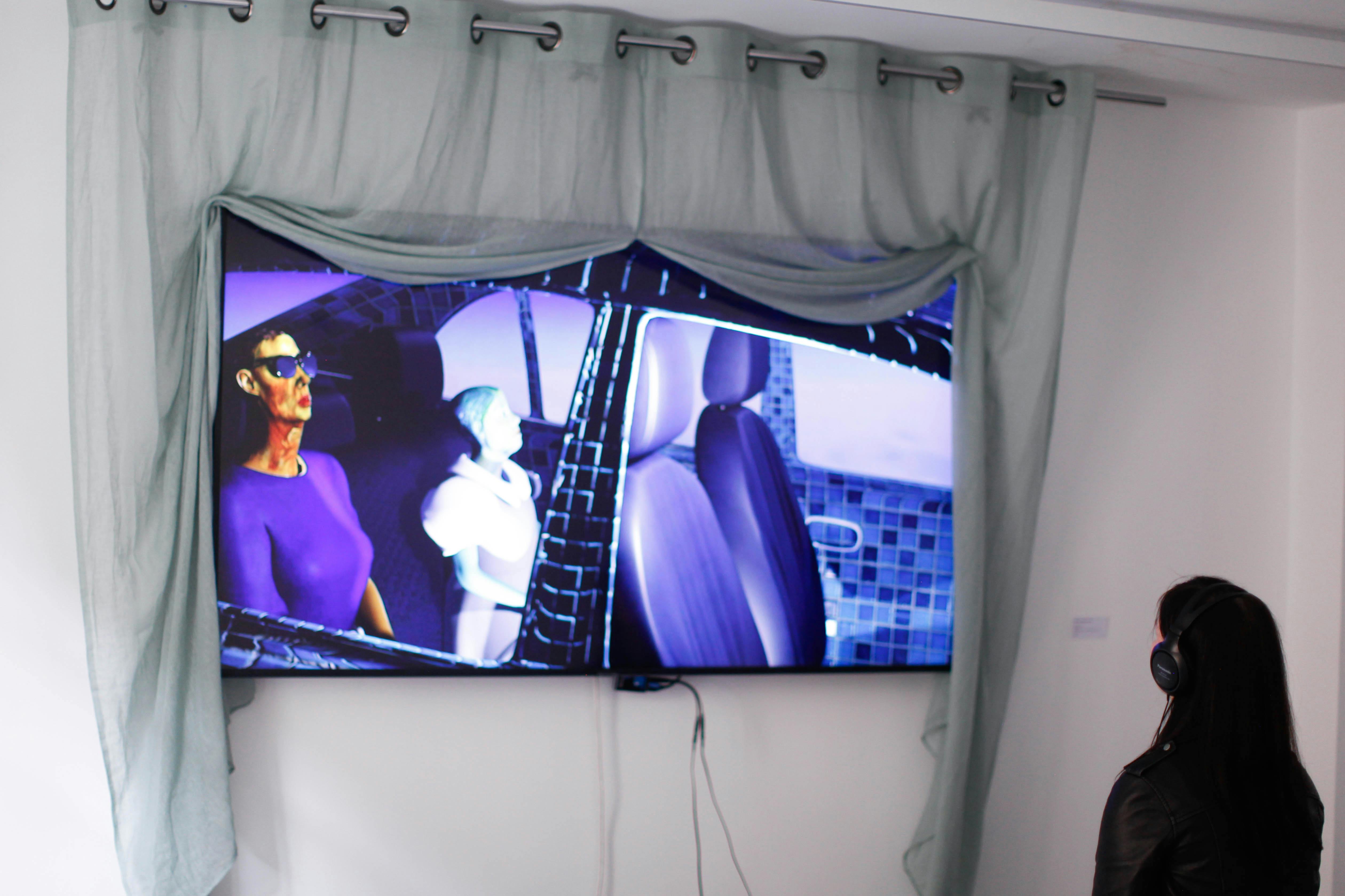 Woman viewing animated digital artwork on wall-mounted screen