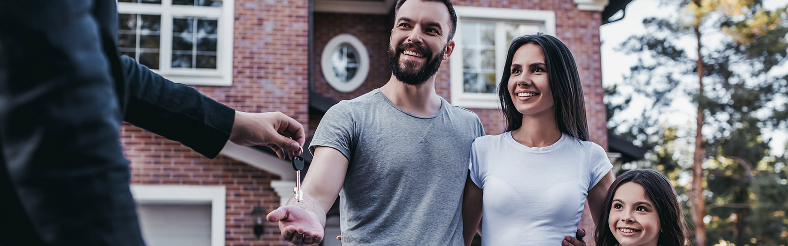 real estate agent handing over home keys to a family