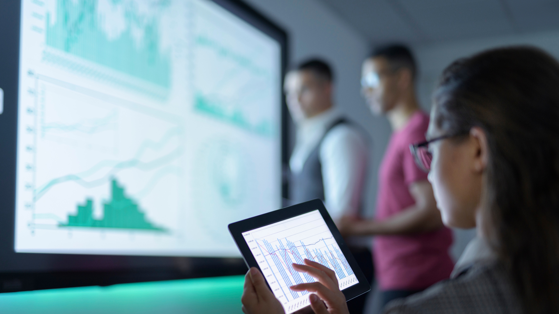 Businesswoman viewing graphs on digital tablet in business meeting