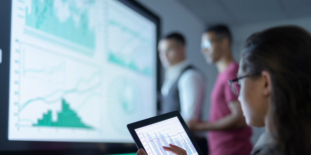 Businesswoman viewing graphs on digital tablet in business meeting