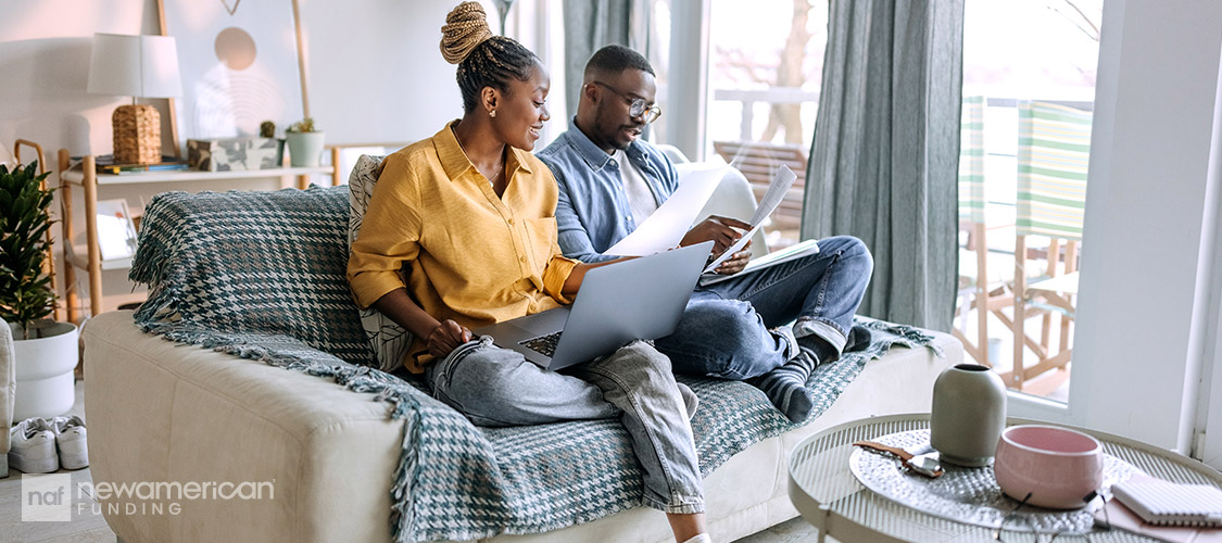 couple in the living room couch going over paperwork