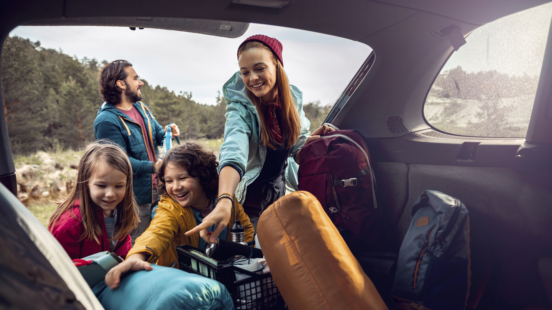 Young family getting the camping supplies out of the car