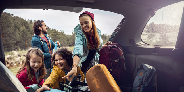 Young family getting the camping supplies out of the car