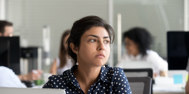 Thoughtful indian businesswoman looking away thinking of problem solution