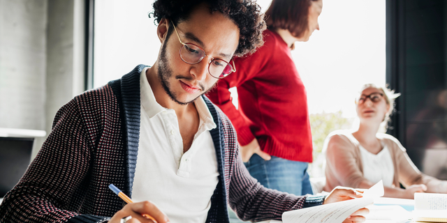 Student Using Calculator To Work Out Math Problem
