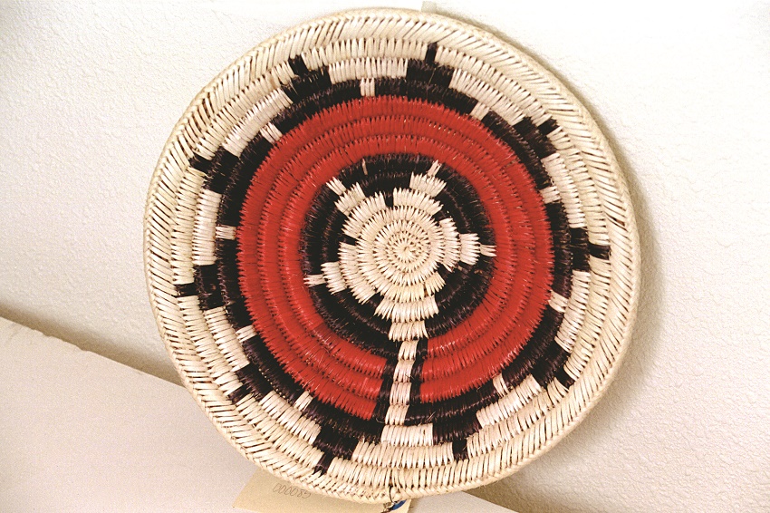 A Navajo basket woven with white, black, and red colors