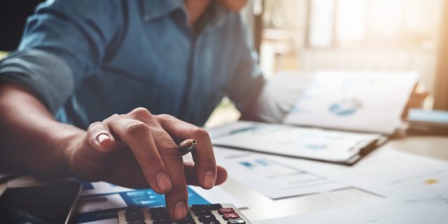 Business accounting concept, Business man using calculator with computer laptop, budget and loan paper in office.