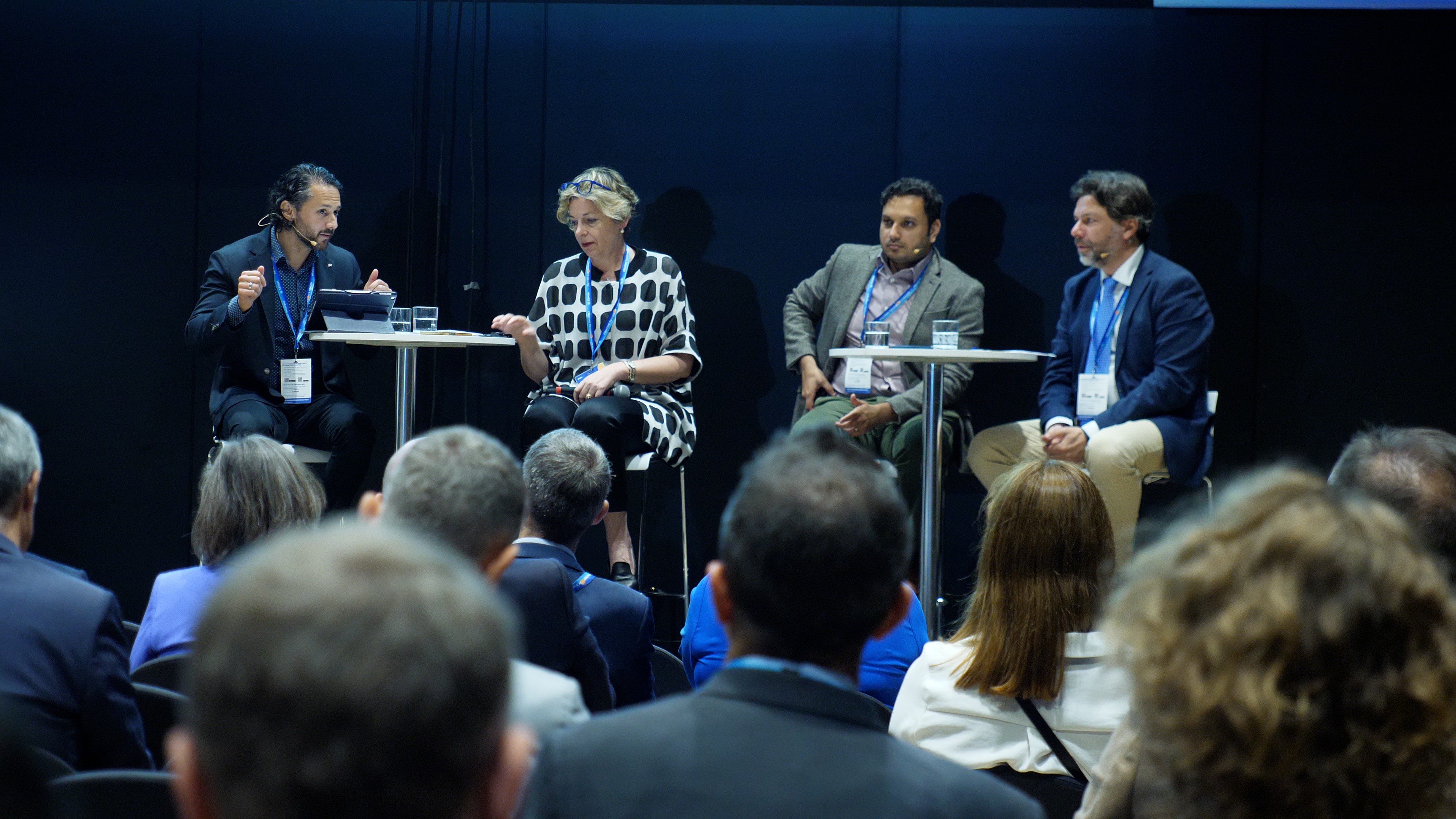 This image shows a panel of experts discussing the challenges and opportunities of AI adoption in healthcare at the HIMSS24 Europe conference.