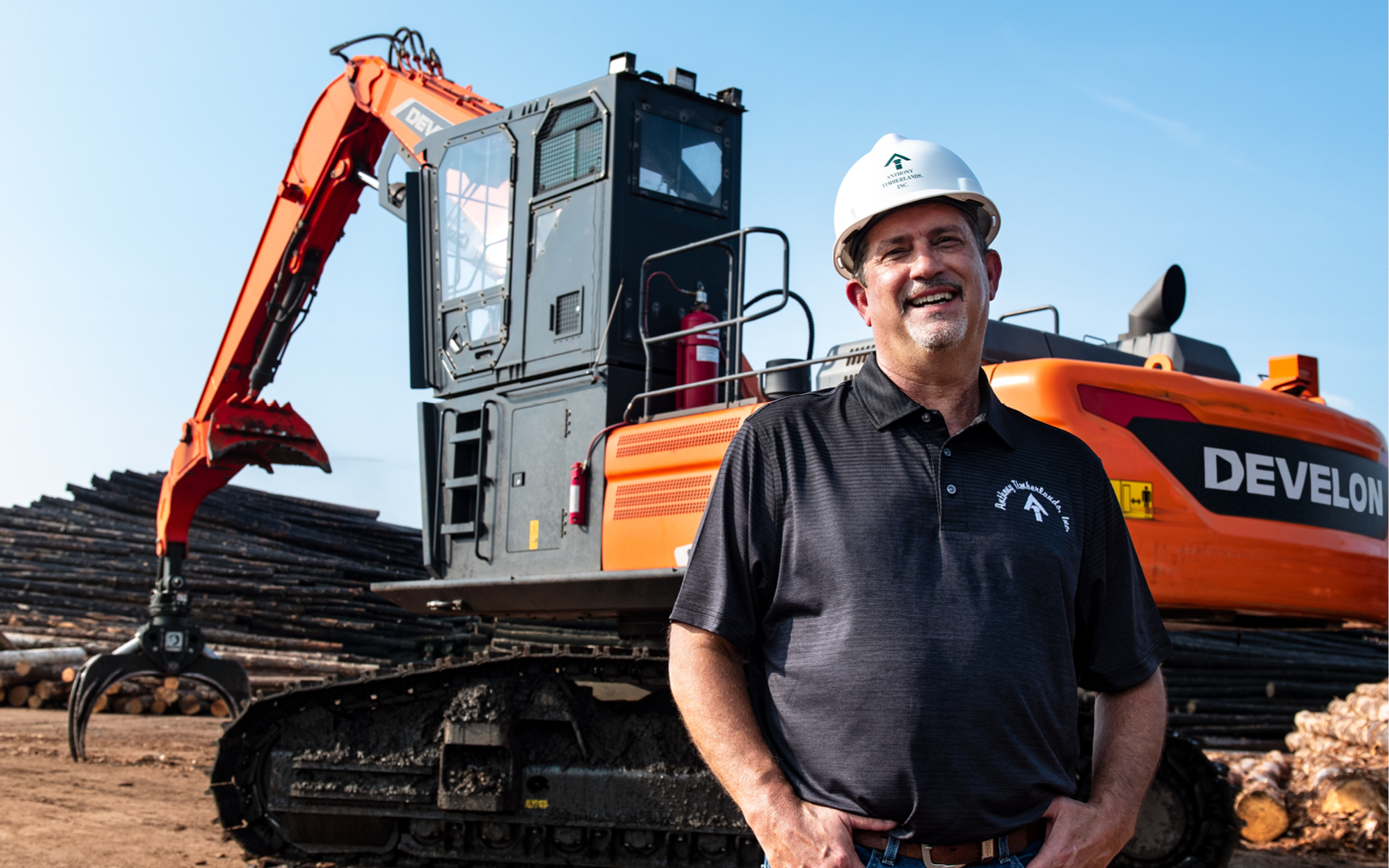 David Bird of Anthony Timberlands and a DEVELON log loader at a sawmill.