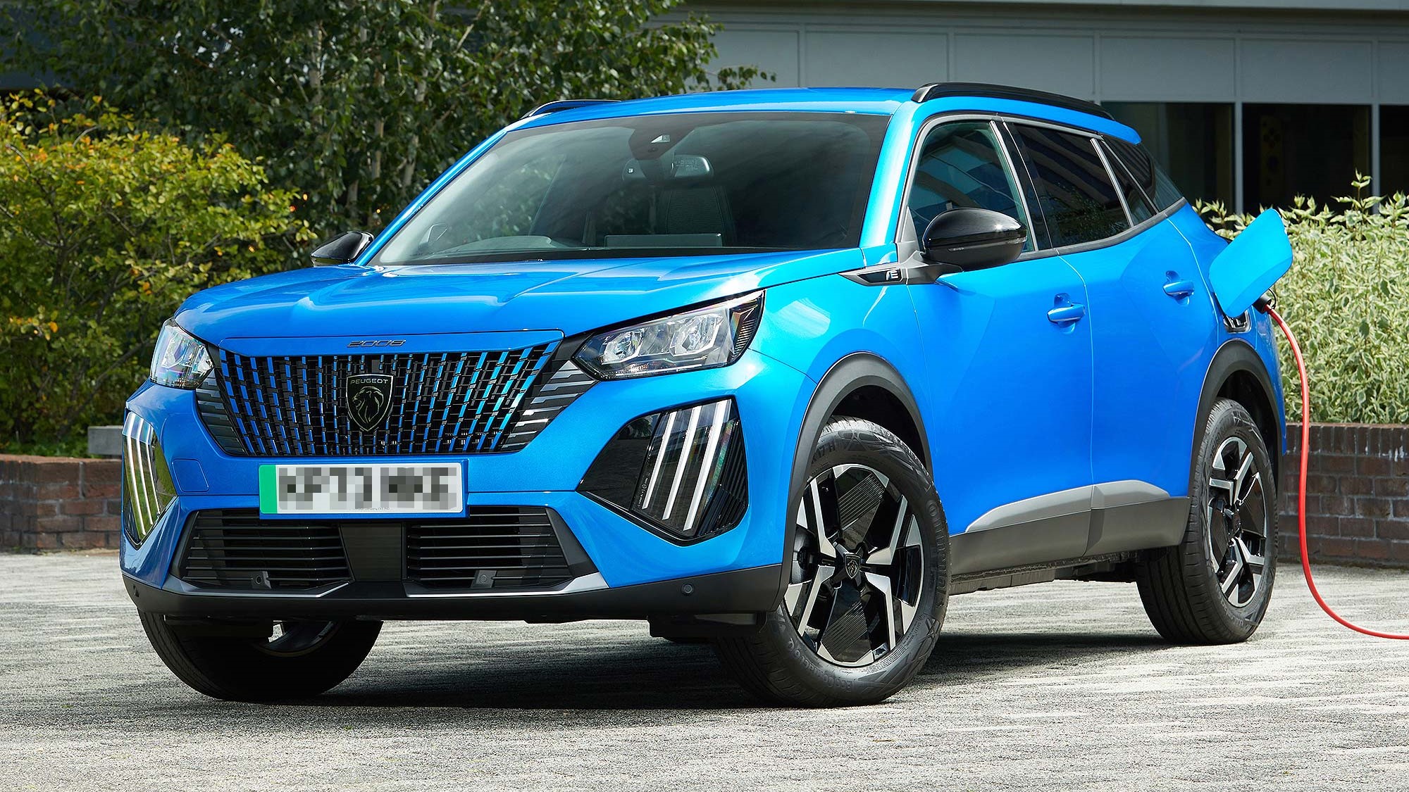 Bright blue Peugeot 2008 parked and charging electrically