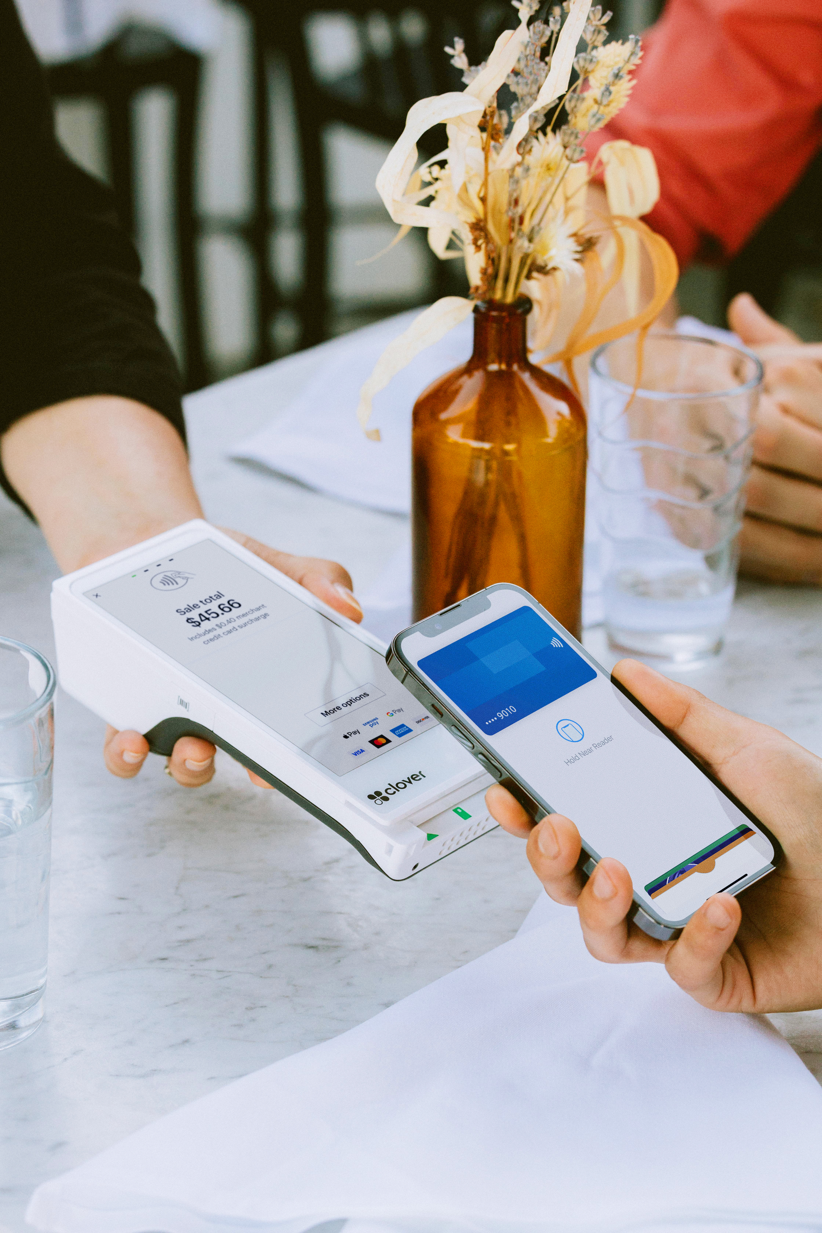 smartphone making contactless payment on a handheld terminal