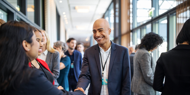 Business executives handshaking at convention center